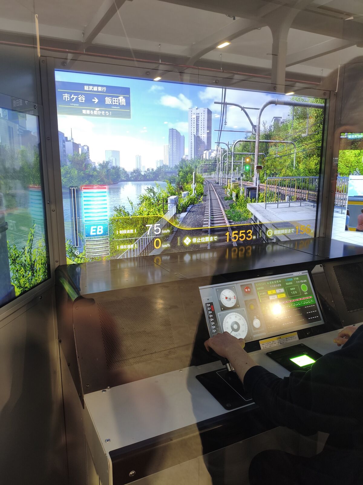 Japanese train simulator with a physical cabin, real controls, and three screens